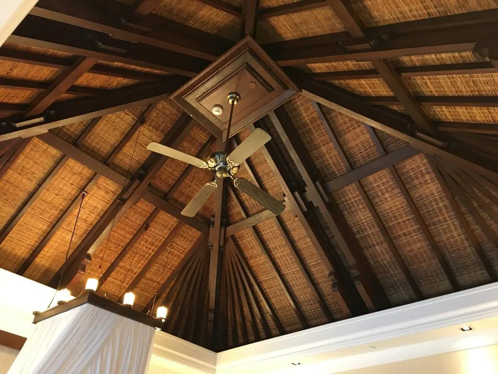 Balinese hipped-roof interior view — exposed timber rafters and woven bamboo ceiling panels