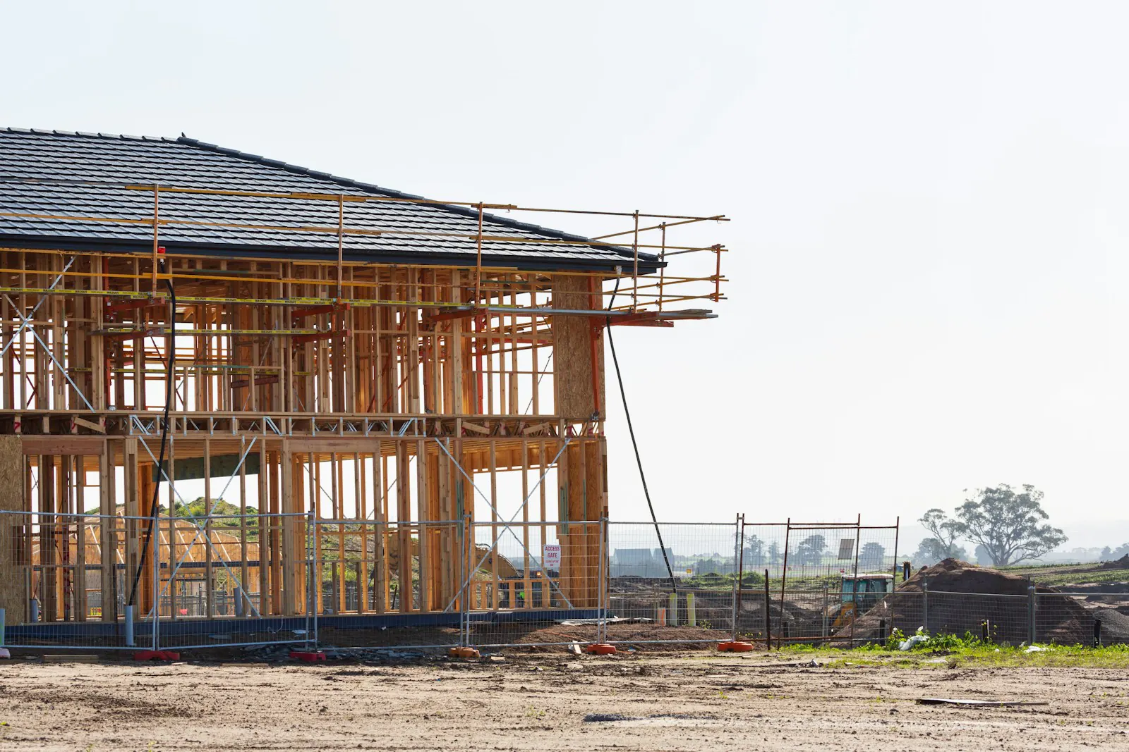 A house wrapped in scaffolding, mid-construction — the kind of stalled site we step in to finish